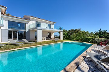A large house with a swimming pool in front of it