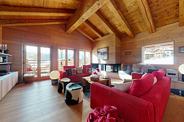 A living room with a red couch and a fireplace