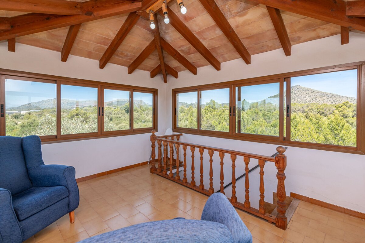 A living room with a staircase and lots of windows