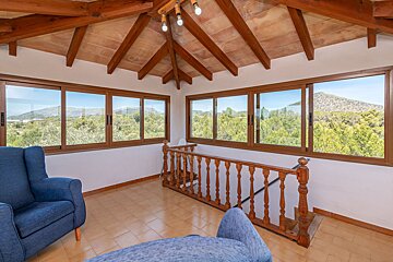 A living room with a staircase and lots of windows