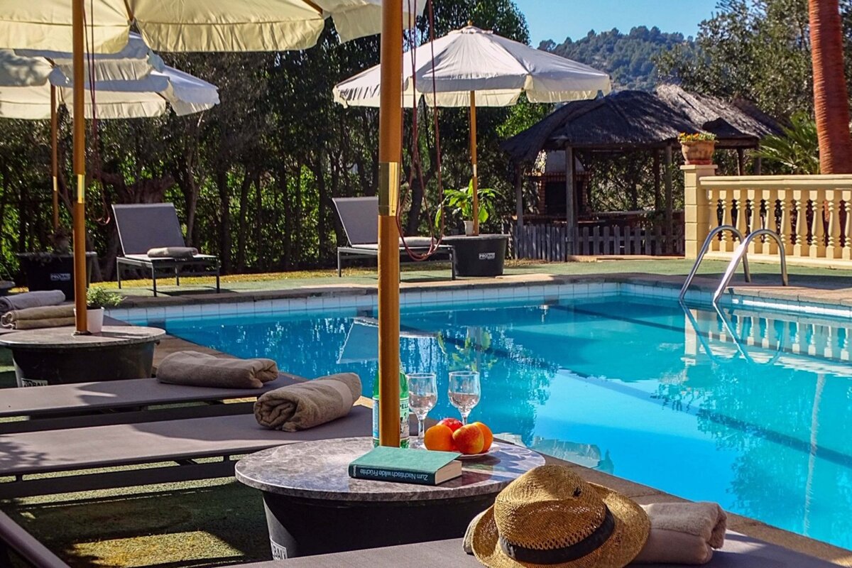 A table with a book on it sits next to a swimming pool