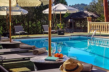A table with a book on it sits next to a swimming pool
