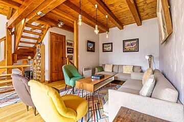 A living room with a couch and chairs and stairs