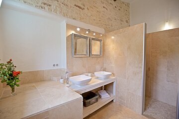 A bathroom with two sinks and a walk in shower