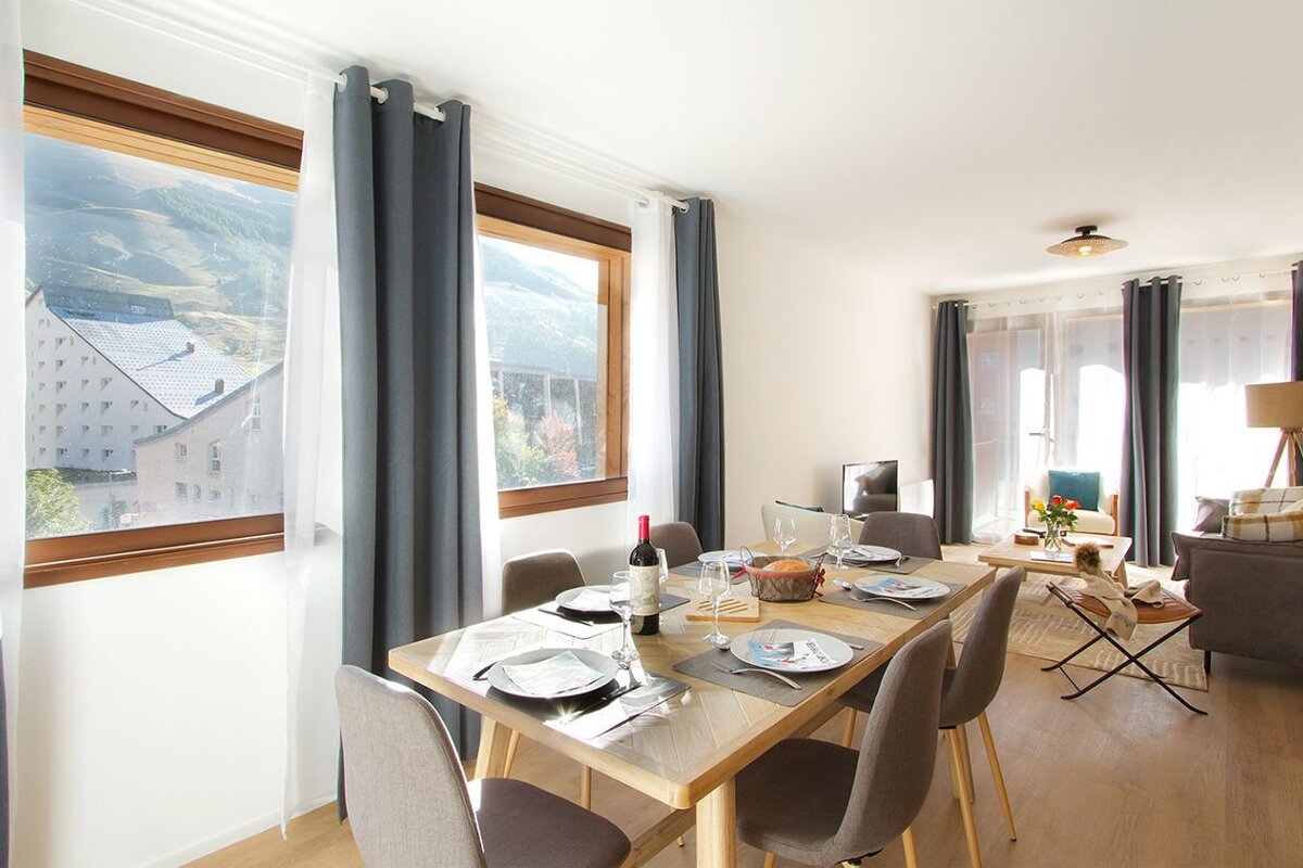 A dining room table with a bottle of wine on it