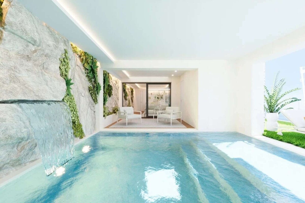 Serene indoor pool with a rock wall, waterfall, and lush vertical garden. Beyond, a chic seating area opens to a sunny outdoor view.
