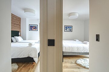 A bedroom with two beds and a picture on the wall