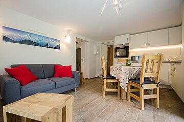 A living room with a couch and a table and chairs