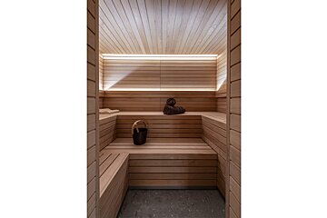 A wooden sauna with a bucket and towels on the benches
