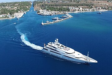 A large white yacht is floating in a body of water