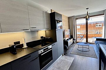 A kitchen with black cabinets and stainless steel appliances