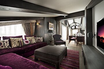 A living room with purple furniture and a flat screen tv