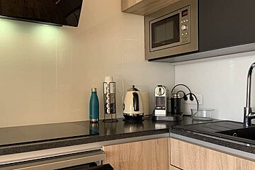 A kitchen with a microwave and a clock that says 10:08