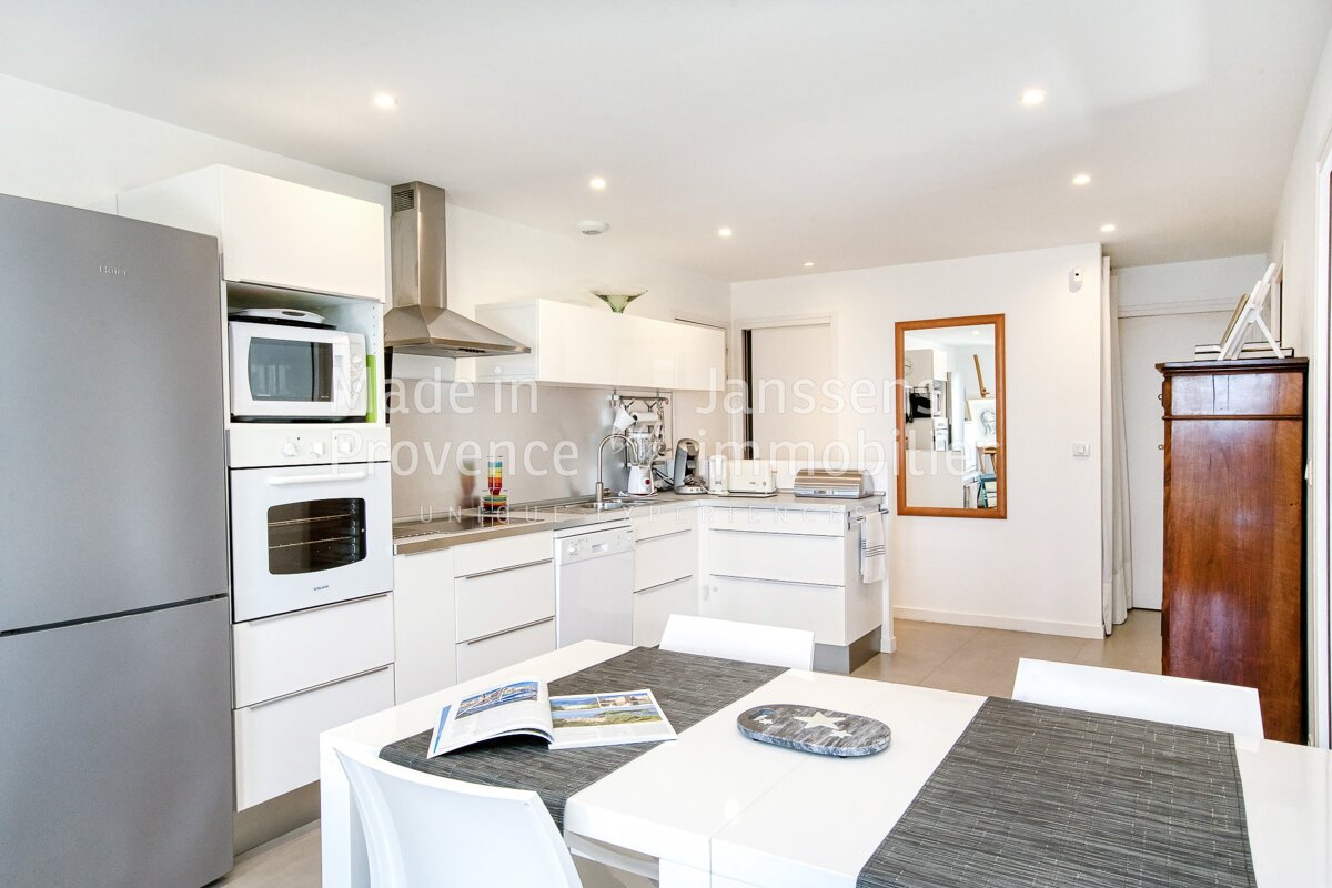 A kitchen with white cabinets and a refrigerator that says made in provence
