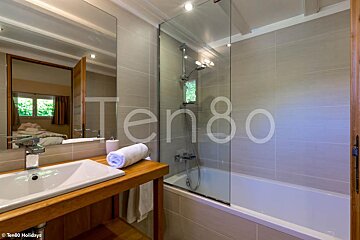 A bathroom with a sink and a bathtub and the word ten80 on the wall