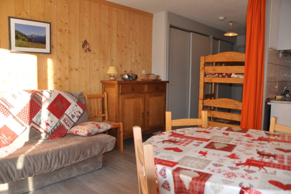 A living room with a couch a table and a bunk bed