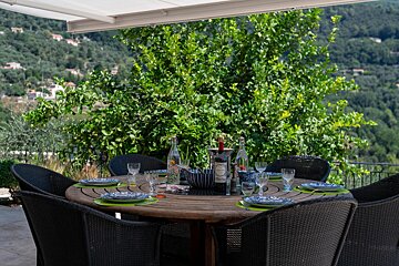 A bottle of wine sits on a table outside