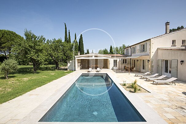 A large house with a large swimming pool in front of it