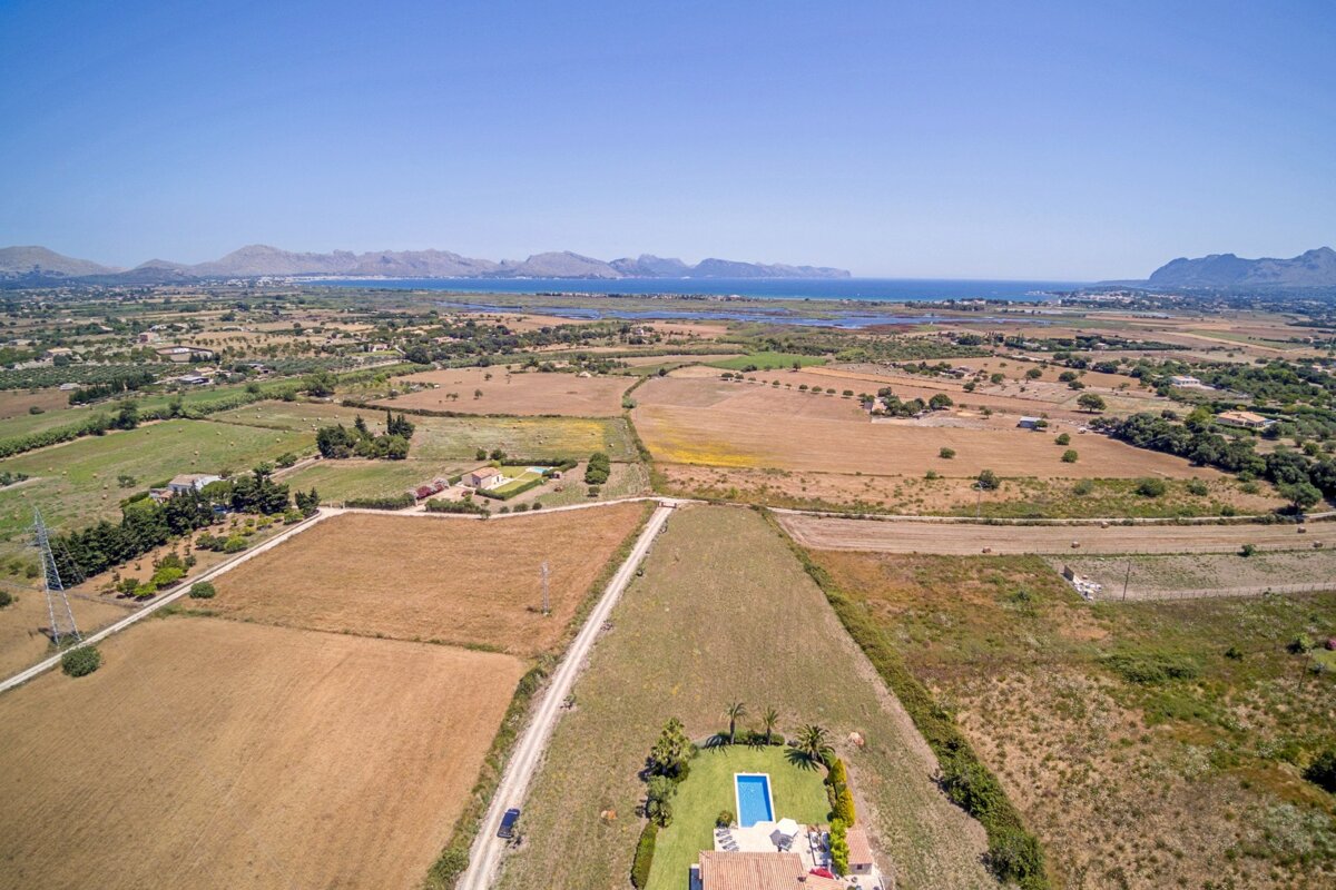An aerial view of a house in the middle of a field