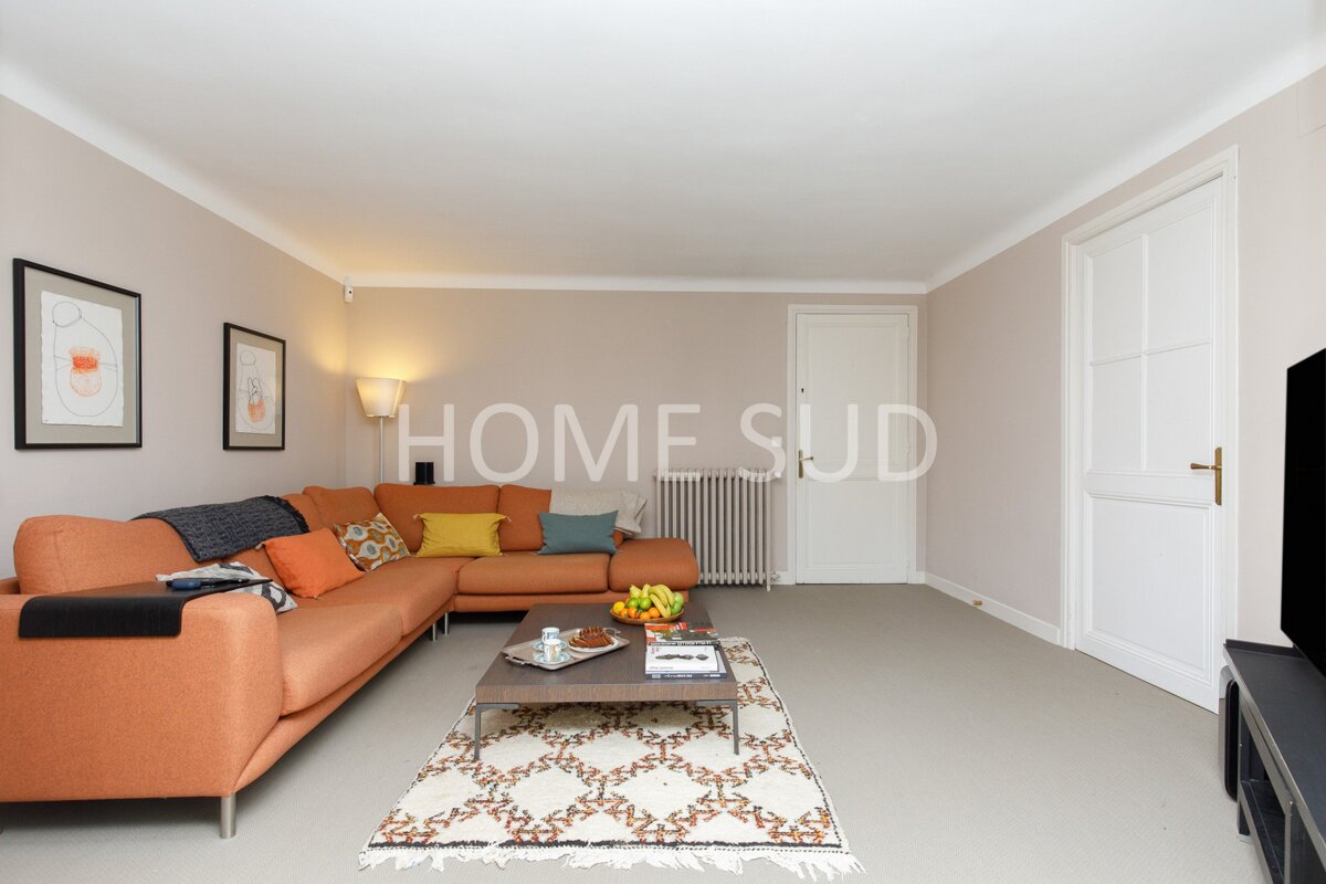 A living room with a couch and a rug that says home sud