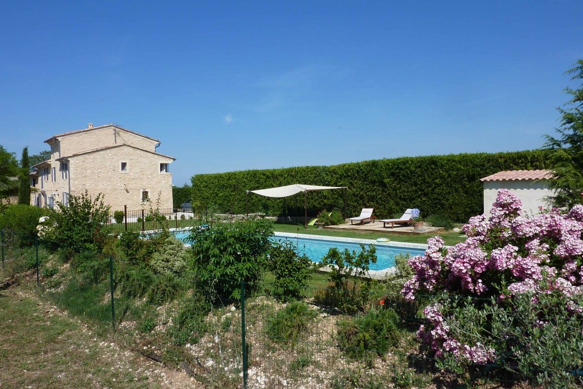 A large house with a swimming pool in front of it