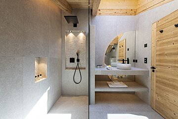 A bathroom with a walk in shower and a sink