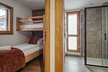A bedroom with bunk beds and a walk in shower