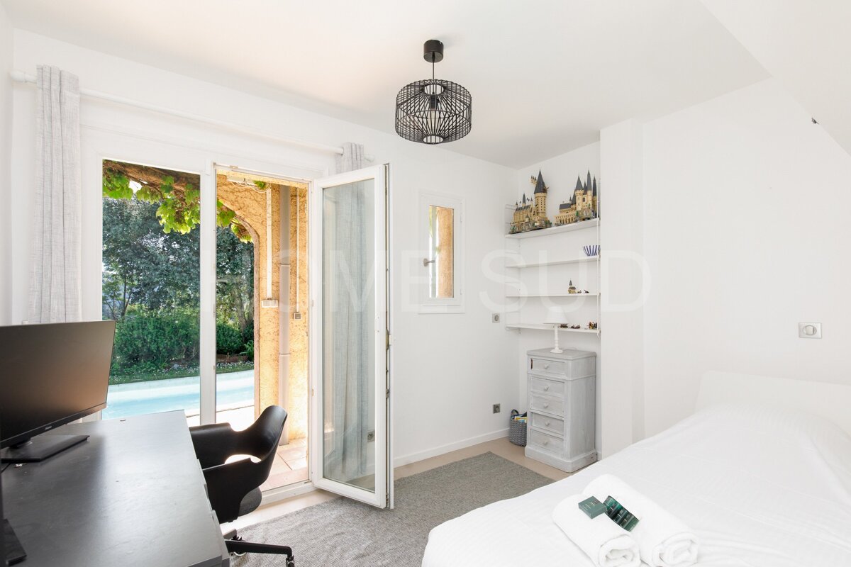 A bedroom with a sliding glass door that leads to a pool