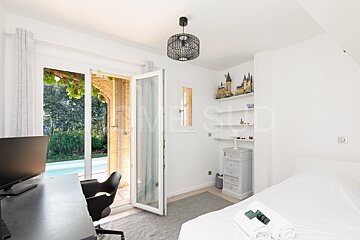 A bedroom with a sliding glass door that leads to a pool