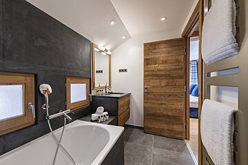 A bathroom with a bathtub a sink and a mirror