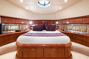 A bedroom with a large bed and purple pillows