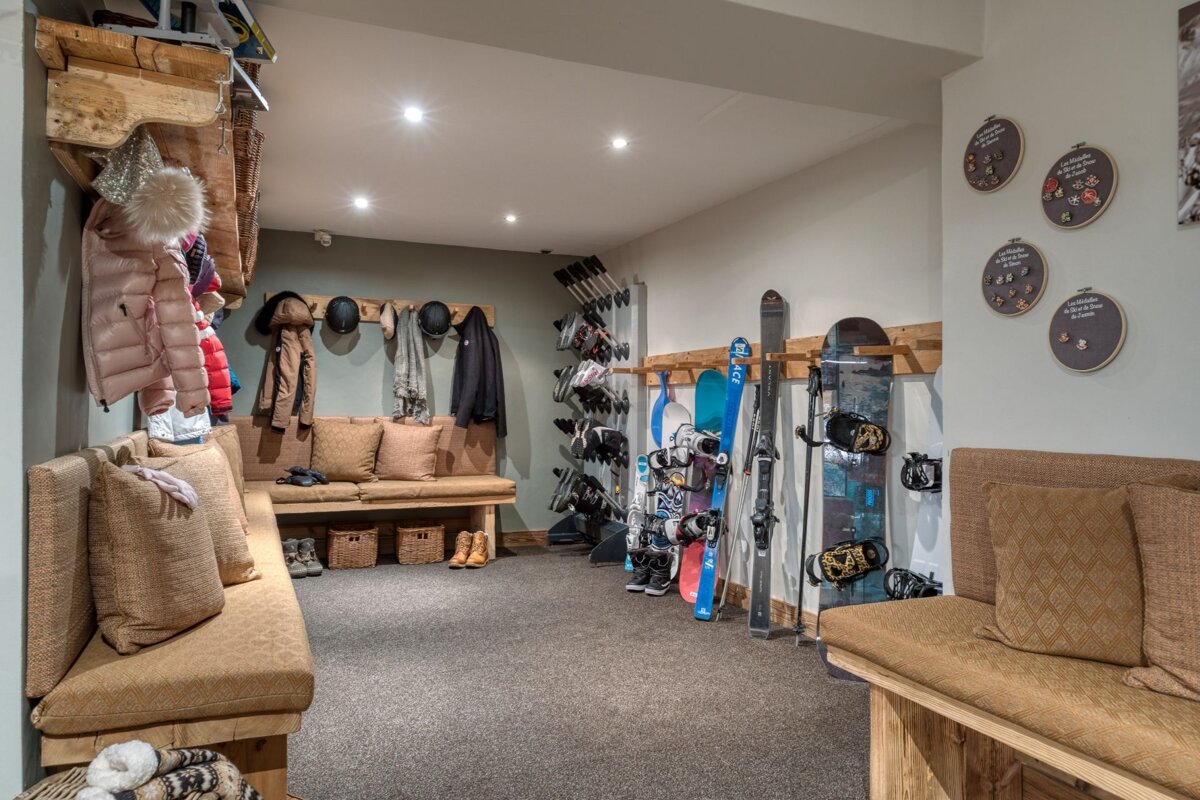 A room with skis and snowboards hanging on racks