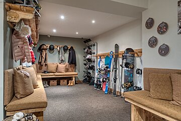 A room with skis and snowboards hanging on racks