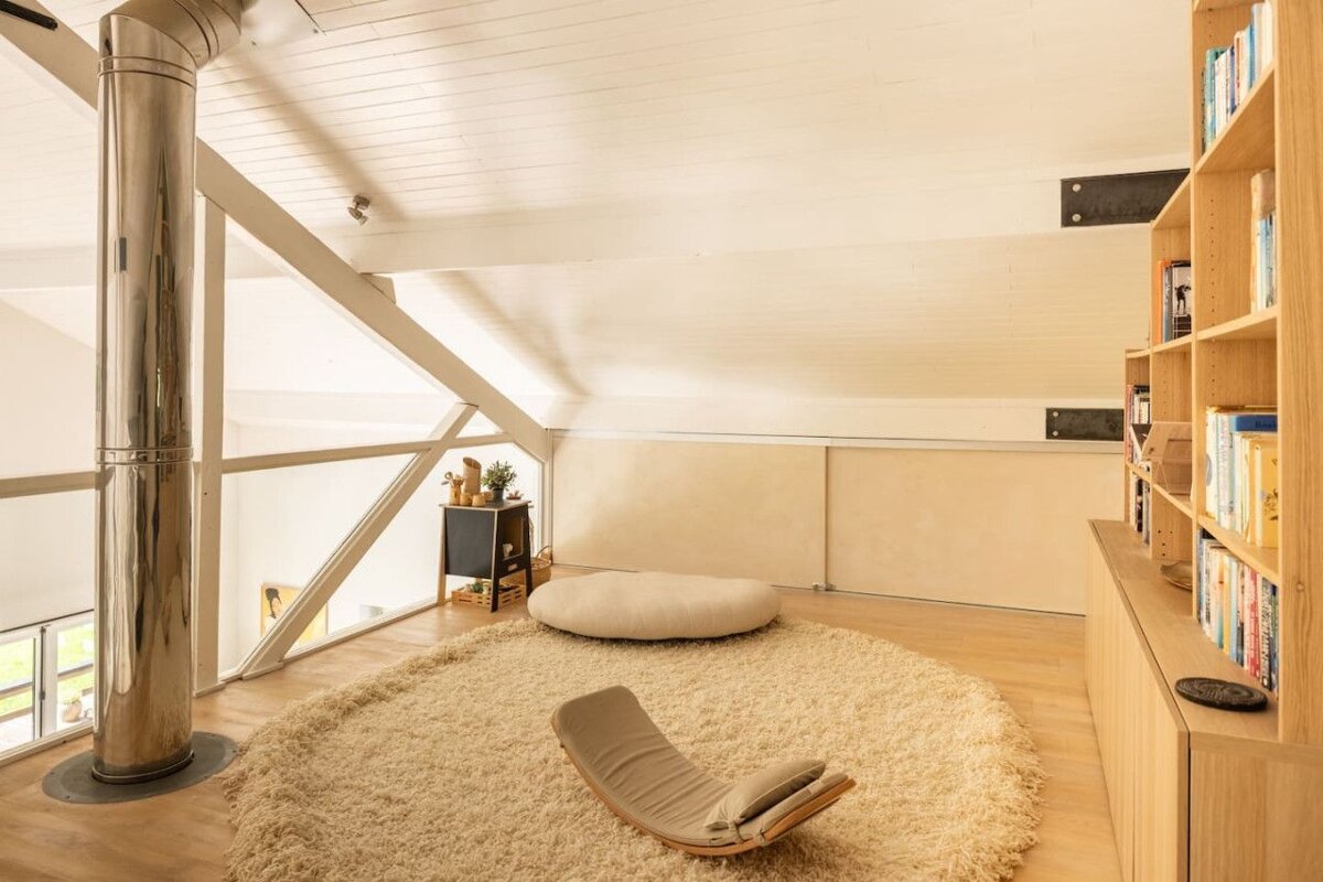 A chair sits on a rug in a room with bookshelves