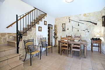 A dining room with a table and chairs and a staircase