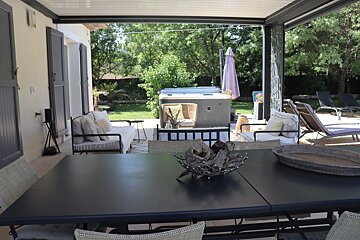 A patio with a table and chairs and a hot tub