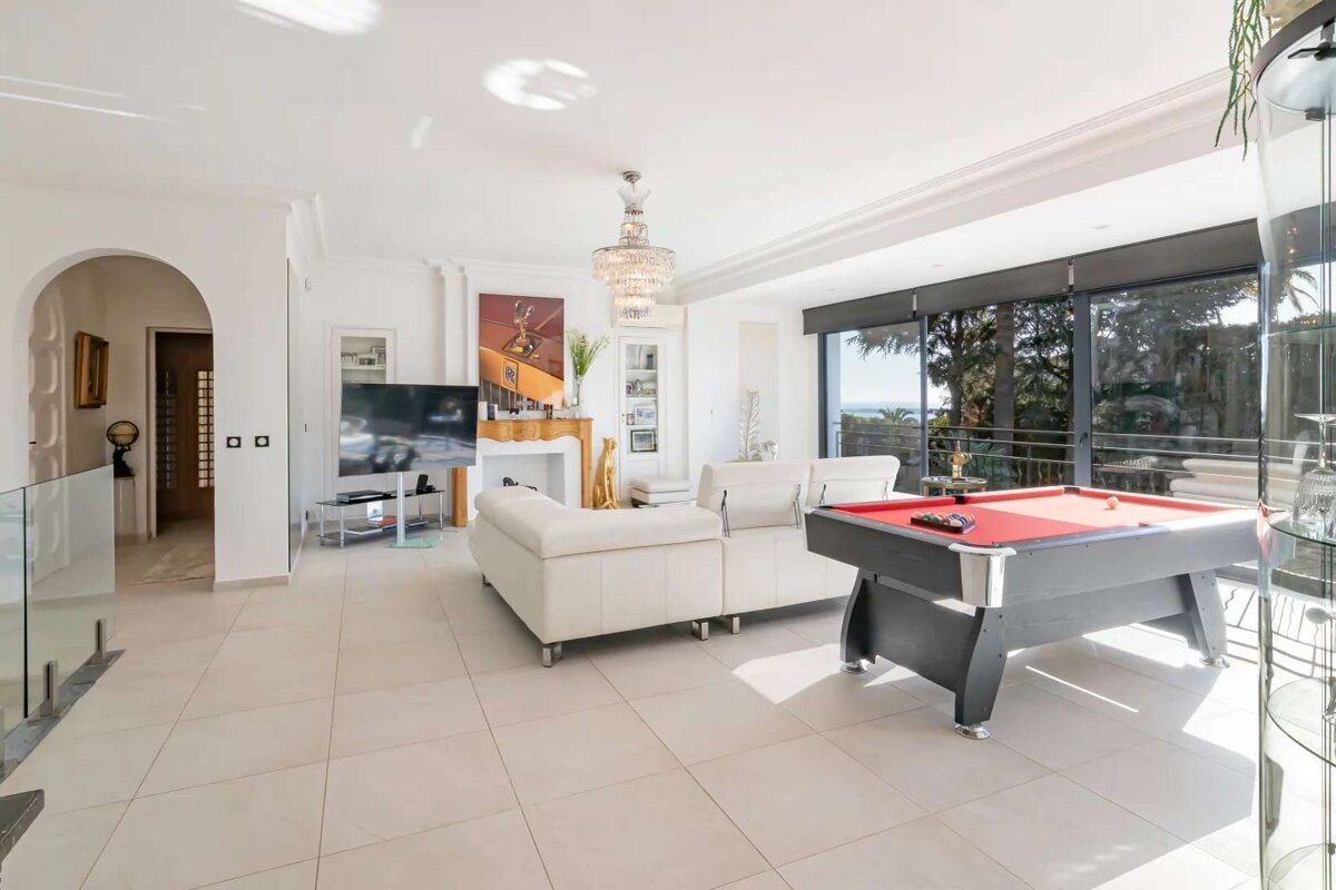 A living room with a pool table and a couch