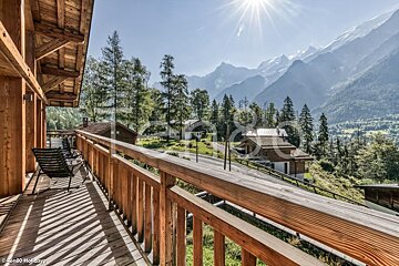 A balcony with a view of mountains and trees