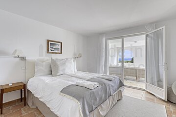 A bedroom with a large bed and a sliding glass door