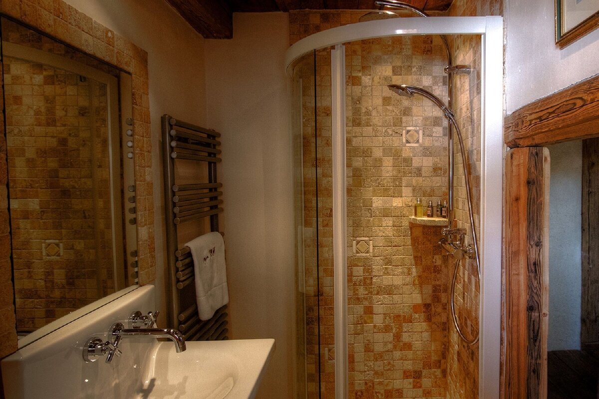 A bathroom with a walk in shower and a sink