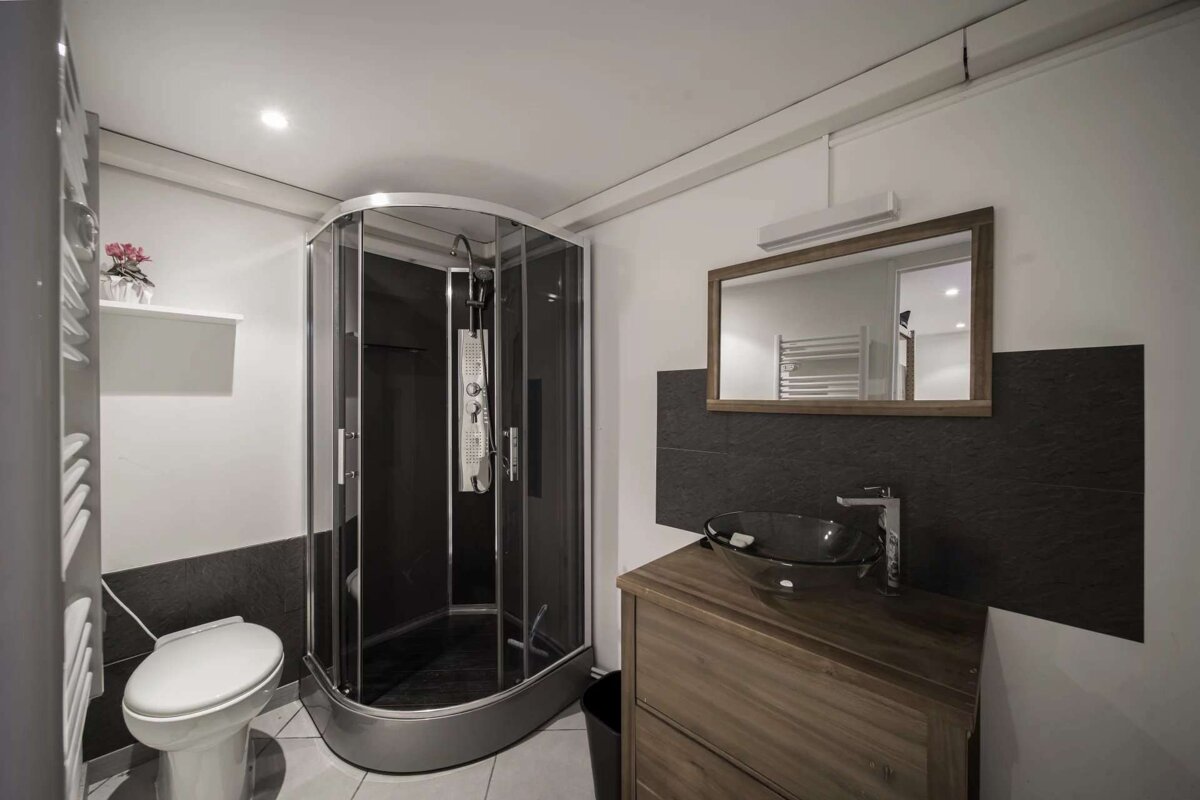 A bathroom with a toilet a sink and a mirror