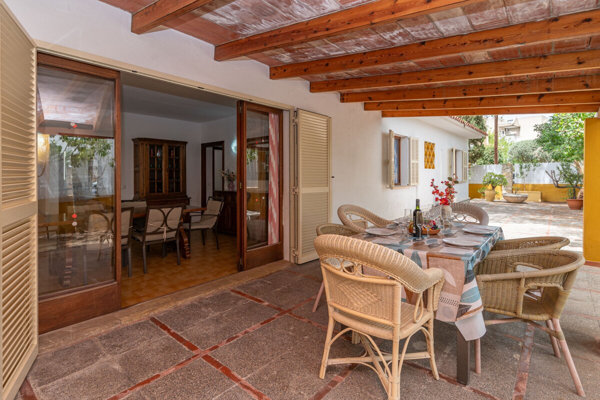A patio with a table and chairs and a bottle of wine