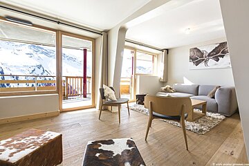 A living room with a couch and chairs and a picture of a moose on the wall
