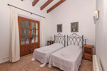 A bedroom with two twin beds and two nightstands