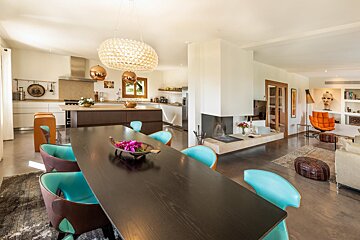 A dining room table with a bowl of flowers on it
