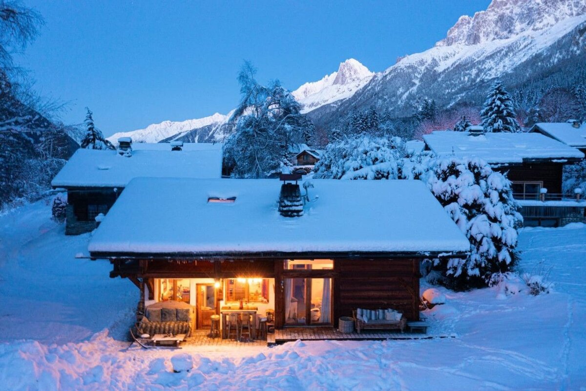 A snowy house with a mountain in the background