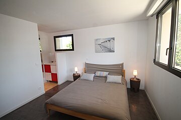 A bedroom with a bed and a picture on the wall