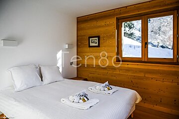 A bedroom with a bed and a window and the word ten80 on the wall