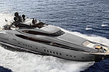 A large gray yacht is floating in the ocean