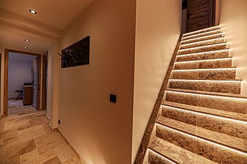 A hallway with stairs leading up to the second floor